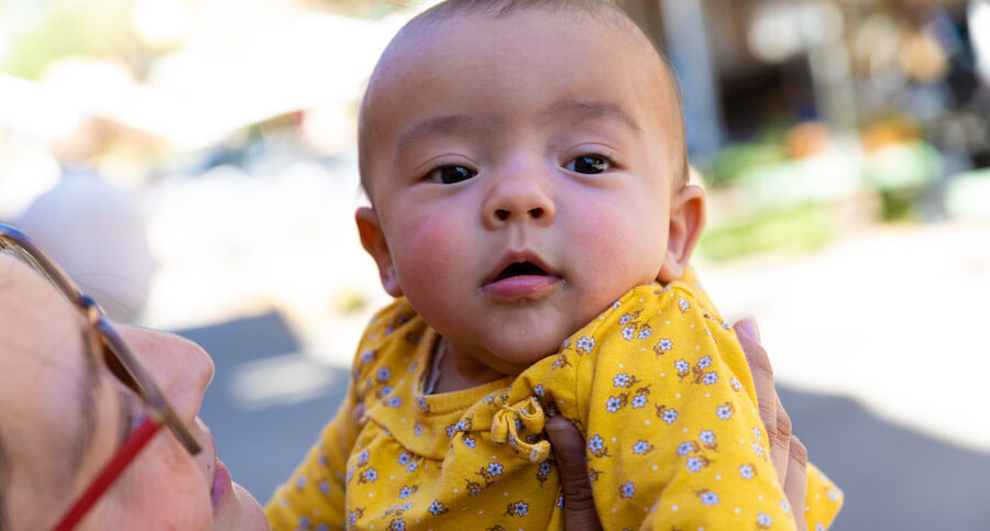 Baby being held aloft by a woman