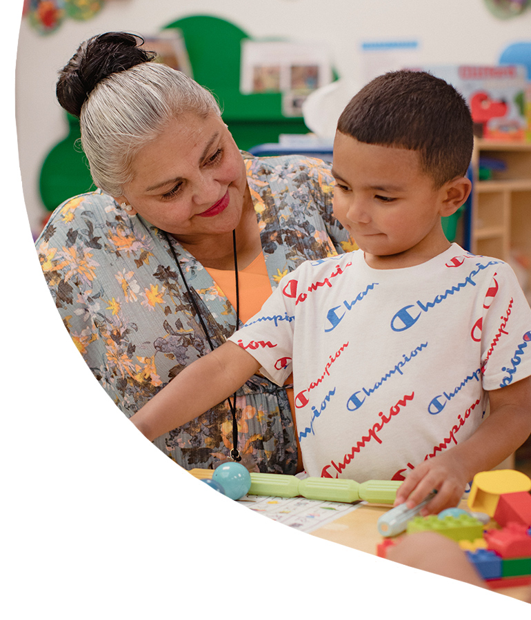 Child care provider with child in classroom