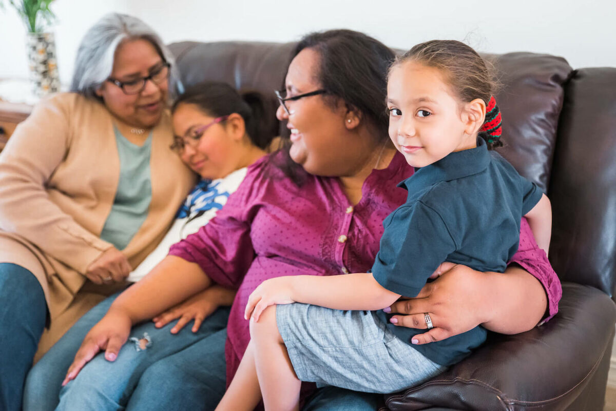 Sandia Pueblo family smiling on the couch